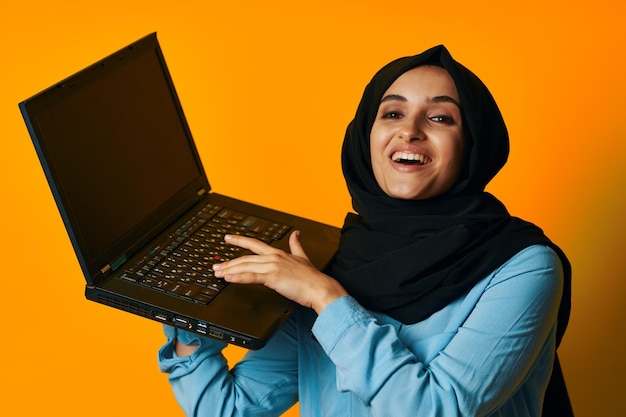 Retrato de una mujer joven usando una computadora portátil en casa