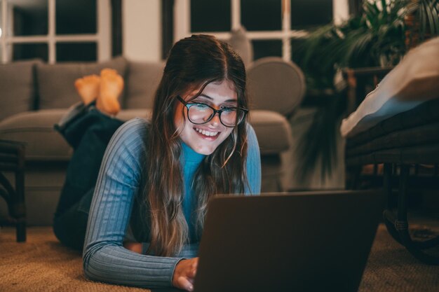 Foto retrato de una mujer joven usando una computadora portátil en la mesa