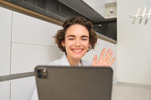 Foto retrato de una mujer joven usando una tableta digital mientras está de pie en la oficina