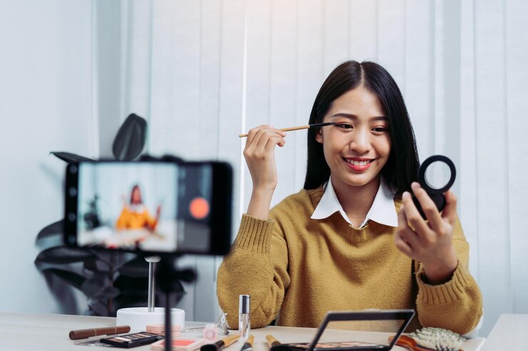 Foto retrato de una mujer joven usando el teléfono mientras está sentada en la mesa