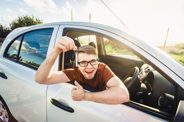 Foto retrato de una mujer joven usando el teléfono mientras está sentada en el coche