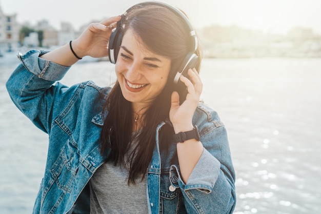 Foto retrato de una mujer joven usando un teléfono móvil al aire libre