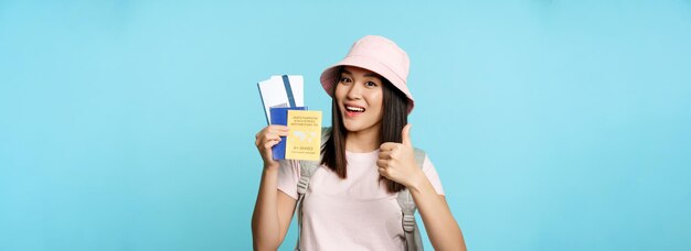 Foto retrato de una mujer joven usando un teléfono móvil contra un fondo azul