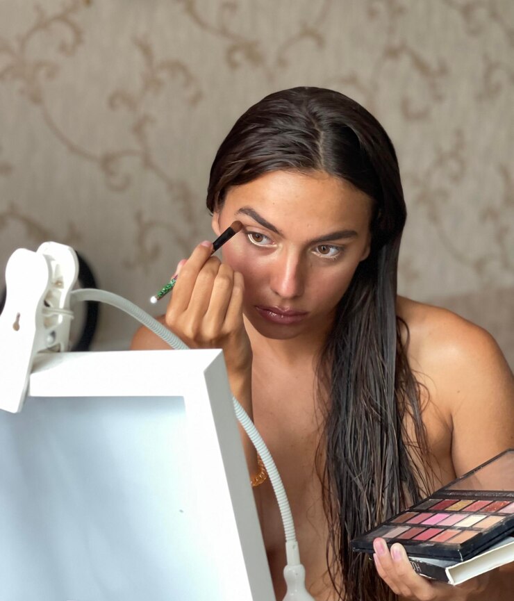 Foto retrato de una mujer joven usando un teléfono móvil contra la pared