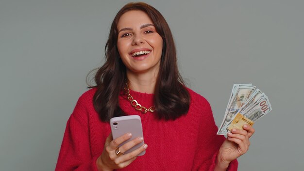 Foto retrato de una mujer joven usando un teléfono móvil contra la pared