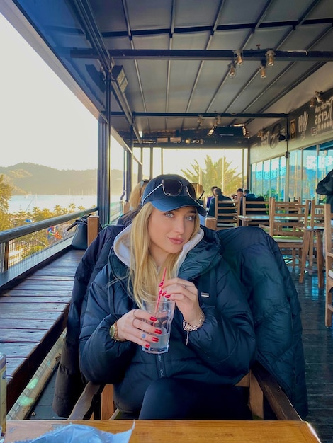 Retrato de una mujer joven usando un teléfono móvil en un restaurante