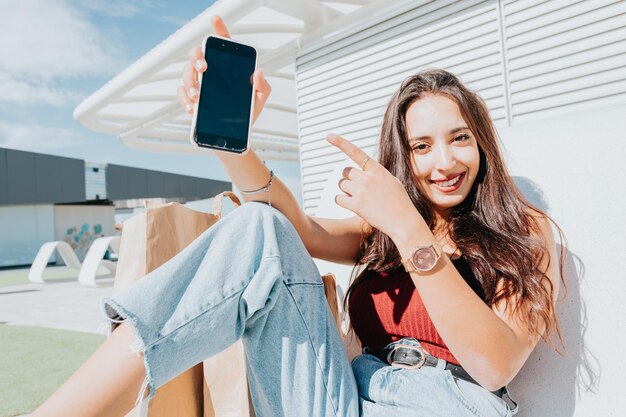 Foto retrato de una mujer joven usando un teléfono móvil