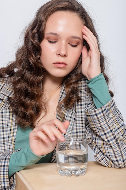 Retrato de mujer joven con vaso de agua Fondo blanco aislado Mujer joven bebiendo agua