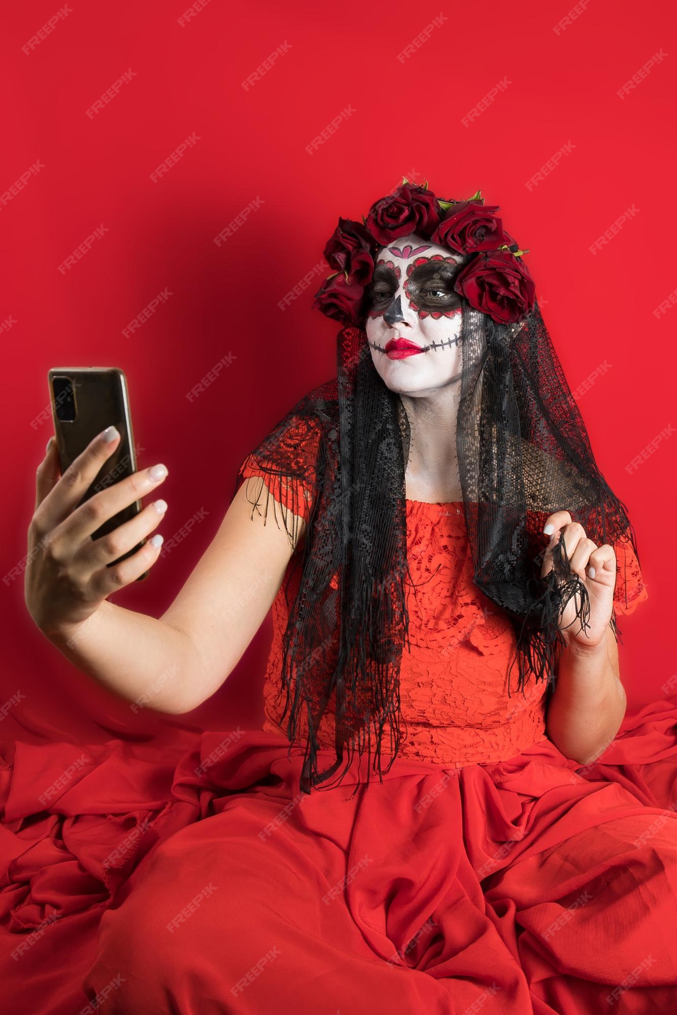 Retrato de una mujer joven con un vestido rojo y maquillaje tradicional de calaveras de azúcar para la celebración del día de los muertos el día de los muertos | Foto Premium Retrato de una mujer joven con un vestido rojo y maquillaje tradicional de calaveras de azúcar para la celebración del día de los muertos el día de los muertos | Foto Premium