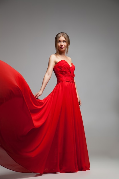 Retrato, de, mujer joven, en, vestido rojo, con, vuelo, skirt., Tiro del estudio