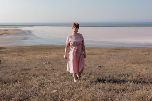 retrato, de, un, mujer joven, en, un, vestido rosa, en el campo