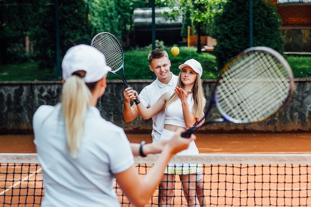 Retrato de una mujer jugando en tenis con entrenador.