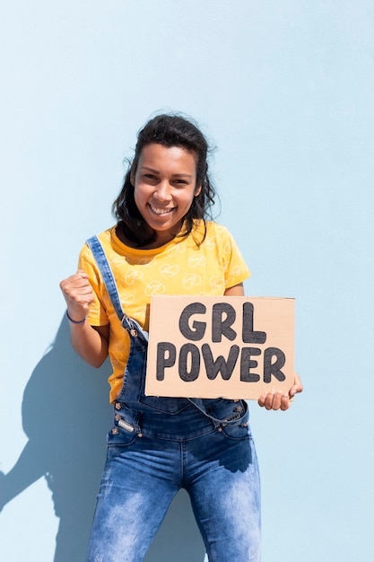 Retrato de una mujer latina sosteniendo una pancarta con el lema Girl Power