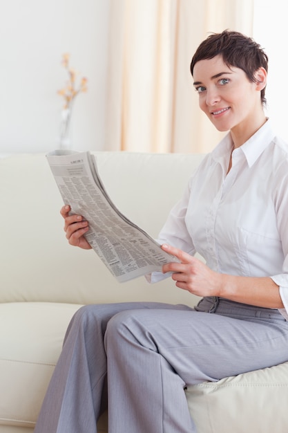 Retrato de una mujer leyendo las noticias mirando a la cámara