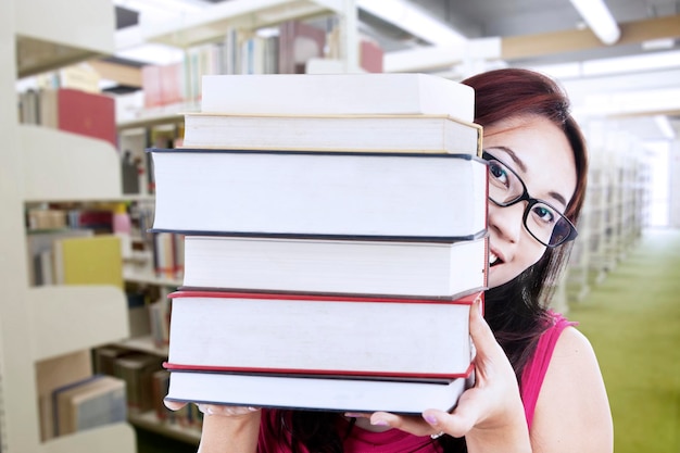 Retrato de una mujer con libros en la biblioteca