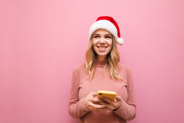 retrato, mujer, llevando, gorro de santa, con, teléfono