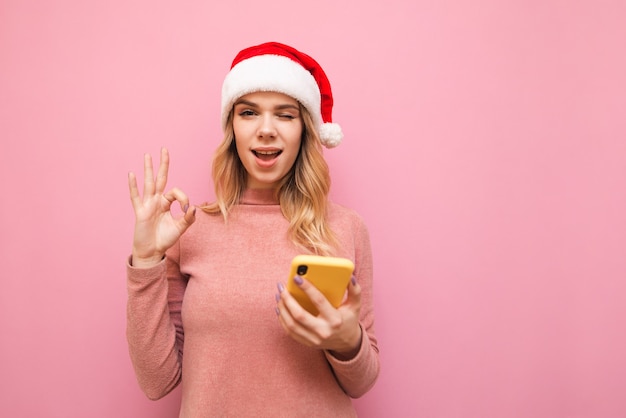 retrato, mujer, llevando, gorro de santa, con, teléfono