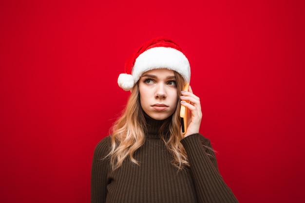 retrato, mujer, llevando, gorro de santa, con, teléfono