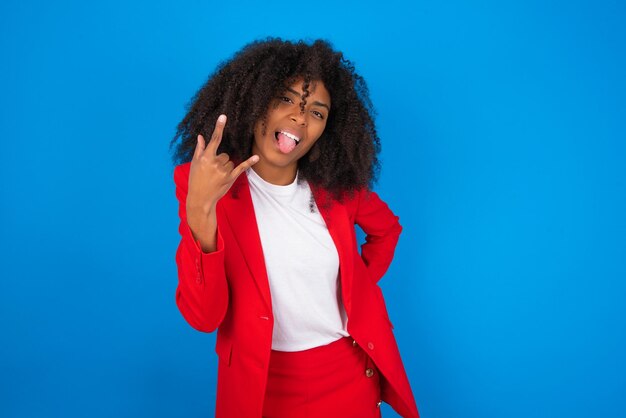 Retrato de una mujer loca que muestra los cuernos de la lengua hacia arriba gesto que expresa emoción