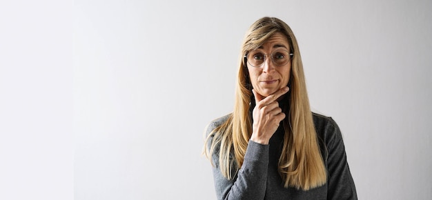 El retrato de una mujer madura con anteojos se ve reflexivo con espacio de copia para su texto individual