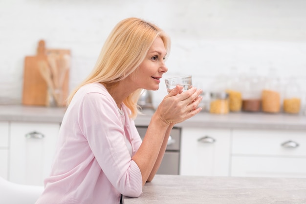 Retrato de mujer madura bebiendo un vaso de agua