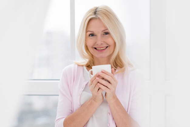 Retrato de mujer madura encantadora sosteniendo una taza