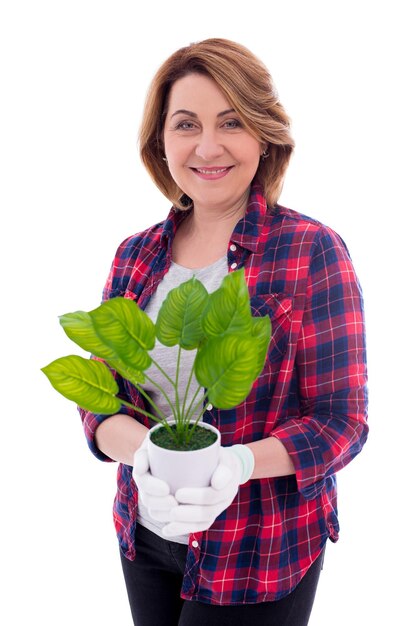 Retrato de mujer madura feliz con planta en maceta aislado sobre fondo blanco.