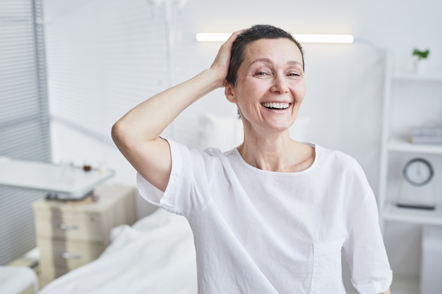 Retrato de mujer madura feliz sonriendo a la cámara ella recuperándose de una enfermedad