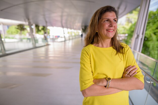 Retrato de mujer madura feliz sonriendo y pensando al aire libre