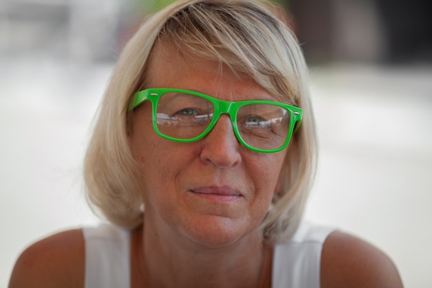 Un retrato de mujer madura con gafas verdes