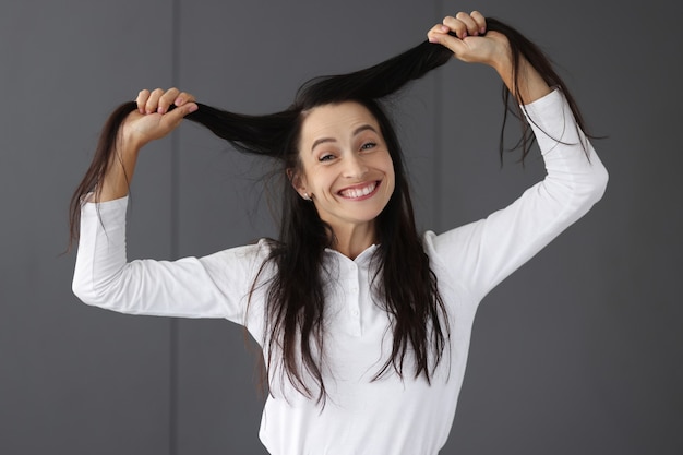 Retrato de mujer madura riendo sosteniendo su cabello alegre feliz bella dama sonriendo