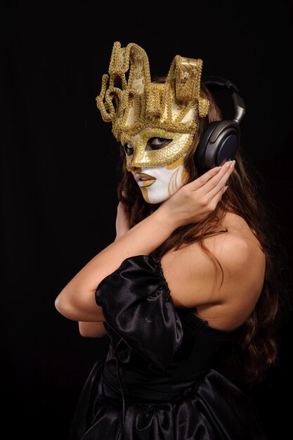 Foto retrato de mujer con máscara de fiesta dorada escuchar música