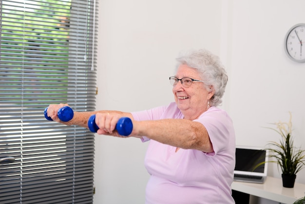 Retrato de una mujer mayor activa y dinámica haciendo deporte fitness en casa