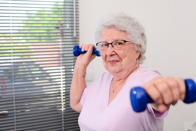 Retrato de una mujer mayor activa y dinámica haciendo deporte fitness en casa