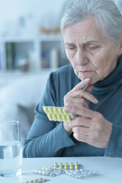 Retrato de mujer mayor enferma tomando pastillas