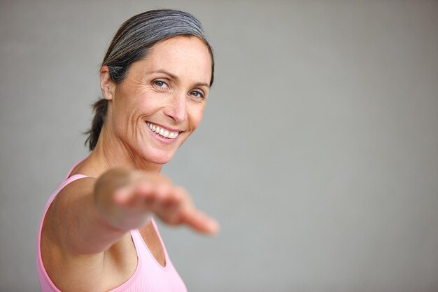 Retrato de mujer mayor y estiramiento de yoga en estudio con espacio de maqueta para equilibrio de salud y ejercicio en el fondo de la pared Meditación facial y mujer madura feliz con zen para hacer ejercicio o paz