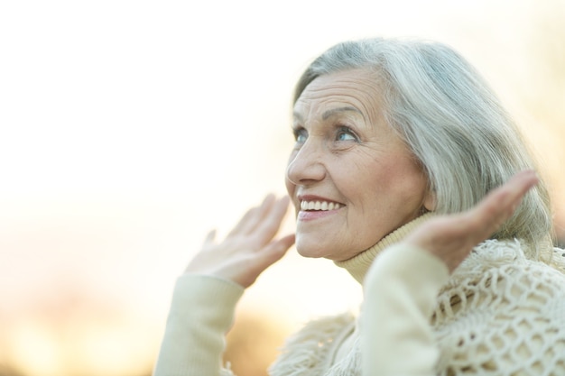 Retrato de mujer mayor feliz al aire libre contra el cielo