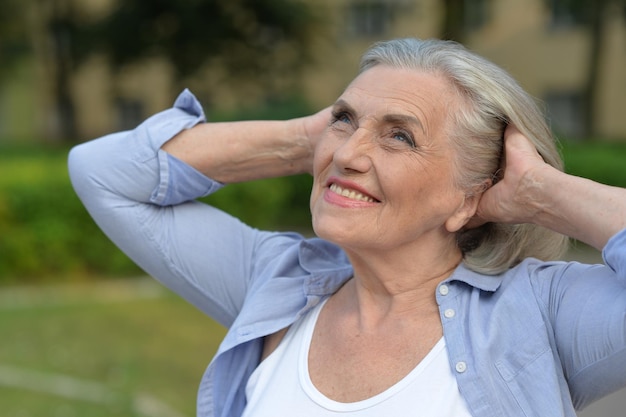 Retrato de una mujer mayor feliz en el parque otoño