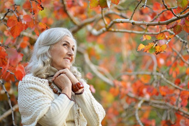 Retrato de una mujer mayor feliz en el parque otoño