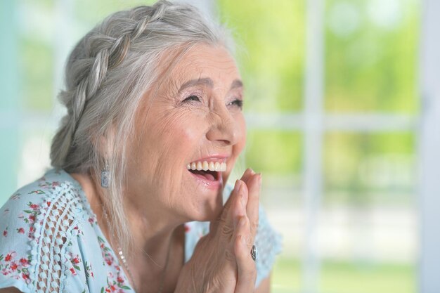 Retrato de mujer mayor feliz posando en casa