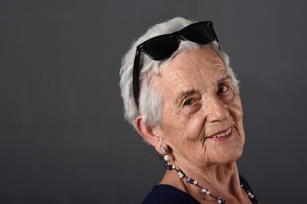 Retrato de una mujer mayor con gafas en la frente