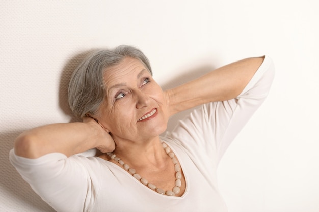 Retrato de una mujer mayor junto a la pared