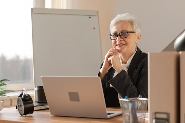 Retrato de una mujer mayor de mediana edad europea con estilo y segura de sí misma en el lugar de trabajo