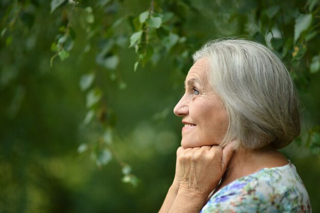 Retrato de una mujer mayor en el parque de verano