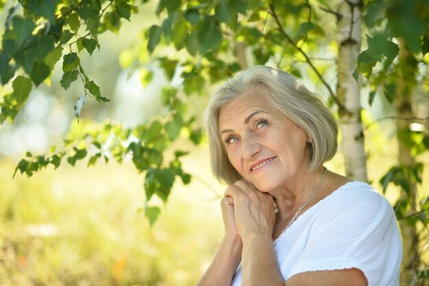 Retrato de una mujer mayor en el parque de verano