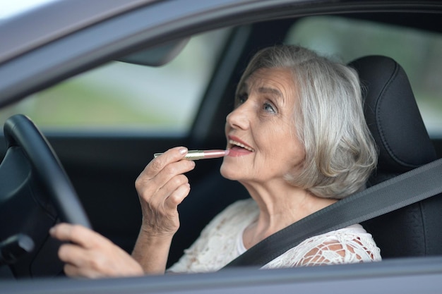 retrato, de, mujer mayor, poner, lápiz labial, en el coche