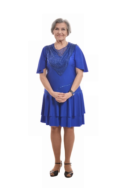 Retrato de mujer mayor sonriente en vestido azul sobre fondo blanco.