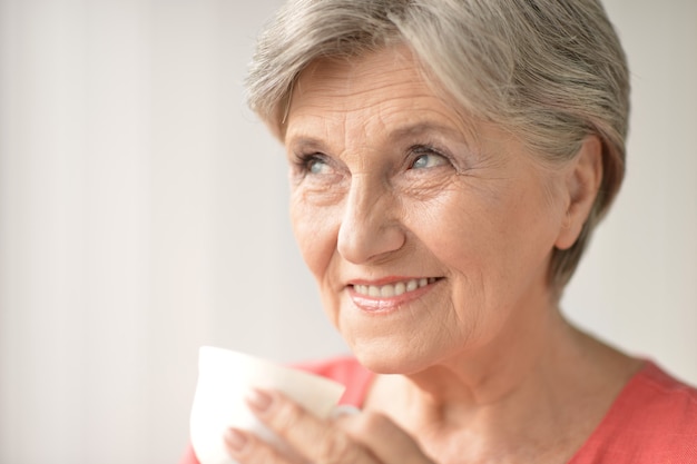 Retrato de una mujer mayor con taza en casa