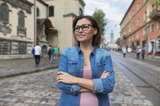 Retrato de mujer de mediana edad con los brazos cruzados en la ciudad