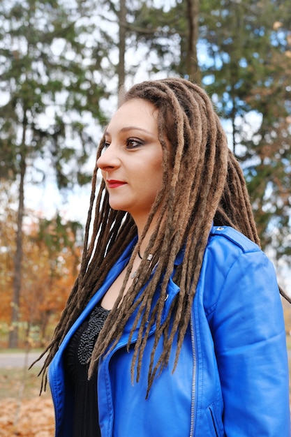 Retrato de una mujer de mediana edad con una chaqueta de cuero azul y rastas